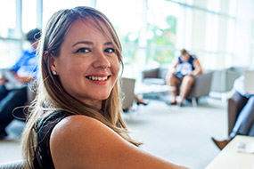 Flexible MBA Student on FAU campus, studying in a lounge